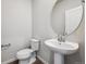 Clean half bathroom with pedestal sink, chrome faucet, and white toilet at 18958 E 94Th Pl, Commerce City, CO 80022
