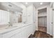 Bathroom featuring double sink vanity, quartz countertop, and walk-in closet at 18958 E 94Th Pl, Commerce City, CO 80022