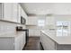 Bright kitchen with white cabinets, stainless steel appliances, a large island, and hardwood floors at 18958 E 94Th Pl, Commerce City, CO 80022