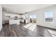 Open-concept kitchen with white cabinets, stainless steel appliances, island, and sliding glass doors at 18958 E 94Th Pl, Commerce City, CO 80022