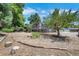 The backyard features a deck, mature trees, and landscaped with rock and mulch at 9227 W 67Th Ave, Arvada, CO 80004