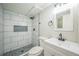 Modern bathroom features a tiled shower with pebble floor and a white vanity with black hardware at 9227 W 67Th Ave, Arvada, CO 80004