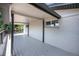 Spacious, covered deck with gray wood flooring and white brick exterior at 9227 W 67Th Ave, Arvada, CO 80004