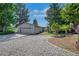 Two-car detached garage with a spacious driveway and gravel landscaping at 9227 W 67Th Ave, Arvada, CO 80004