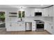 Bright kitchen features white cabinets, stainless steel appliances, herringbone backsplash, and modern countertops at 9227 W 67Th Ave, Arvada, CO 80004