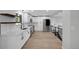 Bright, open kitchen with white cabinets, stainless steel appliances, and views of a staircase at 9227 W 67Th Ave, Arvada, CO 80004