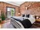 Stylish main bedroom featuring exposed brick wall, decorative steer skull, and ample natural light at 2524 Champa St # 4, Denver, CO 80205