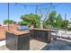 Entertainer's rooftop deck with a built-in outdoor kitchen area, grill, and custom wood accents at 2524 Champa St # 4, Denver, CO 80205