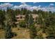 Exterior view of a home in a wooded setting, showcasing natural light and peaceful surroundings at 1682 Montane E Dr, Golden, CO 80401