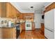 Traditional kitchen features wood cabinets, granite countertops, backsplash, and stainless steel appliances at 11950 E Exposition Ave, Aurora, CO 80012