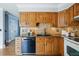 Charming kitchen with oak cabinets, tile backsplash, granite counters, and stainless steel appliances at 11950 E Exposition Ave, Aurora, CO 80012