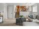 Cozy living room featuring plush carpeting, a staircase, and comfortable seating arrangements at 11950 E Exposition Ave, Aurora, CO 80012
