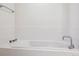 Close-up of a soaking tub in a white tiled bathroom with chrome fixtures at 2958 Syracuse St # 317, Denver, CO 80238