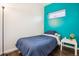 Cozy bedroom featuring hardwood floors, a striking turquoise accent wall, and a comfortable bed at 2958 Syracuse St # 317, Denver, CO 80238