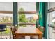 Bright dining area with hardwood floors, a wooden table, and large windows with neighborhood views at 2958 Syracuse St # 317, Denver, CO 80238