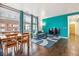 Open living area features hardwood floors, a modern couch, and views from the large windows at 2958 Syracuse St # 317, Denver, CO 80238