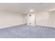 Large basement area with neutral carpet, white walls, and a doorway for potential home upgrades at 3501 W 53Rd Ave, Denver, CO 80221
