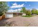 Cozy single-story home boasting a covered porch and a spacious gravel driveway surrounded by mature trees at 3501 W 53Rd Ave, Denver, CO 80221
