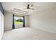Spacious bedroom with tray ceiling, ceiling fan, and large window with a view of green space at 2815 Dreamcatcher Loop, Castle Rock, CO 80109