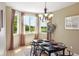 Elegant dining room with a chandelier, a dark wood table set for six, and large windows offering scenic views at 2815 Dreamcatcher Loop, Castle Rock, CO 80109