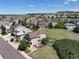 Aerial view of a well-maintained home with fenced backyard and neighborhood featuring lush greenery and mountain views at 2815 Dreamcatcher Loop, Castle Rock, CO 80109