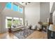 Bright living room with a cozy fireplace, high ceilings, large windows, and comfortable seating, perfect for relaxation at 2815 Dreamcatcher Loop, Castle Rock, CO 80109