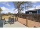 Fenced backyard with mature tree, seating area, and gravel border at 7221 E 66Th Pl, Commerce City, CO 80022