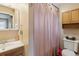 Bathroom features a shower, a vanity with sink, and wood storage cabinet at 7221 E 66Th Pl, Commerce City, CO 80022
