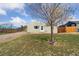 Well-maintained home with a green lawn, complimented by the bright sky and a mature tree at 7221 E 66Th Pl, Commerce City, CO 80022