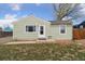 Charming home with a well-maintained lawn and complemented by the trees and blue skies above at 7221 E 66Th Pl, Commerce City, CO 80022
