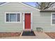 Welcoming red front door, complemented by a well-kept exterior, and a small metal bench at 7221 E 66Th Pl, Commerce City, CO 80022