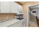 Cozy kitchen features white cabinetry, modern appliances, and sleek countertops at 7221 E 66Th Pl, Commerce City, CO 80022