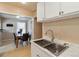 Galley kitchen features stainless steel sink and a view into the dining area at 7221 E 66Th Pl, Commerce City, CO 80022
