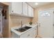 Bright kitchen features white cabinets, marble countertops, and a stainless steel sink at 7221 E 66Th Pl, Commerce City, CO 80022