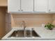 Bright kitchen features white cabinets, marble countertops, and a stainless steel sink at 7221 E 66Th Pl, Commerce City, CO 80022
