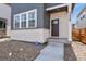 Close-up of the charming front entrance with light stone accents and a dark wood front door at 23920 E 34Th Ave, Aurora, CO 80019