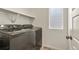 Convenient laundry room with modern washer, dryer, and overhead shelving at 23920 E 34Th Ave, Aurora, CO 80019