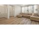 Bright living room featuring an L-shaped sofa, large windows, and an entrance door at 23920 E 34Th Ave, Aurora, CO 80019