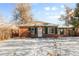 Front exterior of brick home with green shutters, and a snow covered yard at 1570 Xanthia St, Denver, CO 80220