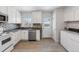 Updated kitchen with white cabinets, stainless steel appliances, and a stylish backsplash at 1570 Xanthia St, Denver, CO 80220