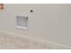 Wall in a bright laundry room, featuring white walls, tile floor, and an opening for the dryer vent at 17959 Dandy Brush Ln, Parker, CO 80134