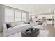Bright, open-concept living space with modern white furnishings flowing into the kitchen and dining area at 17959 Dandy Brush Ln, Parker, CO 80134