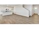 Bright, open living area with hardwood floors, white walls, and views into the kitchen and stairway at 17959 Dandy Brush Ln, Parker, CO 80134