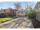 A well-maintained backyard featuring a brick house and a spacious green lawn area with a wooden fence at 1633 Gaylord St, Denver, CO 80206