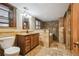Bathroom featuring stone tiling, bathtub, vanity with countertop and dark wood cabinets at 1633 Gaylord St, Denver, CO 80206