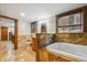 Stone tiled bathroom with bathtub, stone and wood vanity, and natural light at 1633 Gaylord St, Denver, CO 80206