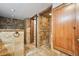 Bathroom showcasing tiled shower, storage unit and natural stone flooring at 1633 Gaylord St, Denver, CO 80206