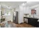 Well-lit kitchen with stainless steel refrigerator, appliances, and dark cabinets at 1633 Gaylord St, Denver, CO 80206
