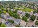 An aerial view shows the neighborhood featuring mature trees, well-kept lawns and a community park with playground equipment at 11845 W Tulane Dr, Morrison, CO 80465