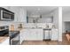 Featuring white cabinets and stainless steel appliances, the kitchen is bright and well-equipped at 11845 W Tulane Dr, Morrison, CO 80465